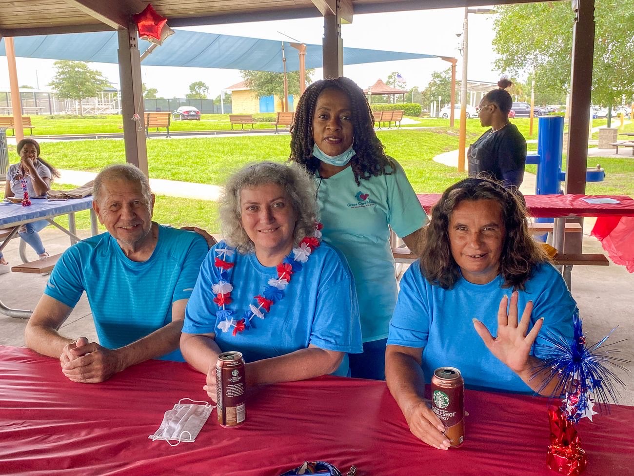 Caregiver Litha Antoine with residents at a summer gathering hosted by Grace Touch Home Care in Palm Coast, Florida